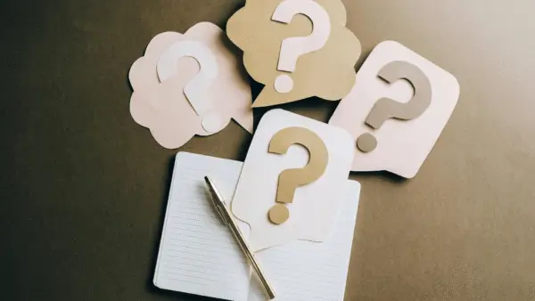 Notebook and question marks on a table
